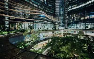 Ein atemberaubendes Beispiel für innovative Architektur: geschwungene Ebenen mit üppiger Vegetation, die sich durch ein modernes Gebäude schlängeln.