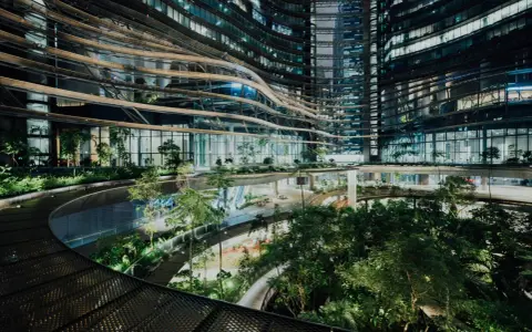 Ein atemberaubendes Beispiel für innovative Architektur: geschwungene Ebenen mit üppiger Vegetation, die sich durch ein modernes Gebäude schlängeln.