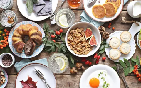 Leckere Brunch-Idee: Marmorkuchen, Müsli, Pancakes, Obst und ein Spiegelei auf rustikalem Holztisch.