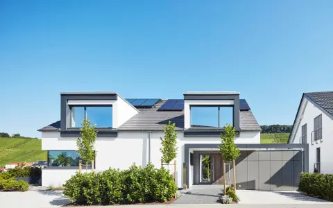 Modernes Einfamilienhaus mit Solaranlage, gestaltet von einem erfahrenen hausbau architekt. Klare Linien und viel Licht prägen das Bild.