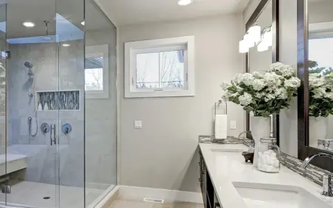 Modernes Badezimmer mit freistehender Wanne und Glasdusche. Die Dusche zu sanieren war eine gute Idee, um diesen Raum aufzuwerten.