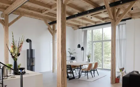 Moderne umgebaute Scheune mit Holzbalken und großem Fenster. Tolle Scheune umbauen Ideen für ein helles Wohnambiente.