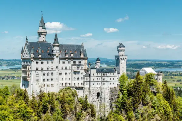 Märchenschloss Neuschwanstein, ein Meisterwerk romantischer Architektur, thront auf einem Felsen über einer malerischen Landschaft.