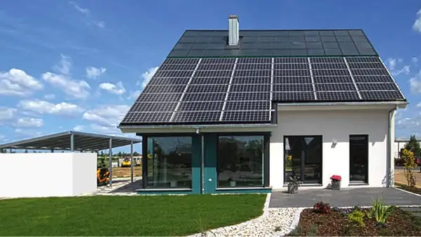Ein modernes, energieautarkes Haus mit Solarmodulen auf dem Dach und einer Photovoltaik-Anlage auf dem Carport.