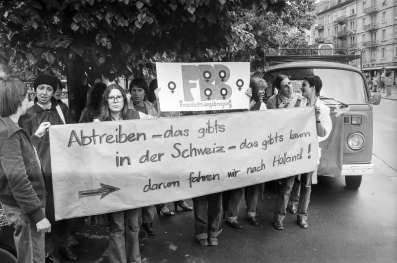 Frauen demonstrieren für das Recht auf Abtreibung. Die Botschaft "Abtreiben – das gibts in der Schweiz – das gibts kaum, darum fahren wir nach Holland!" zeigt eine frühe Welle des Feminismus.